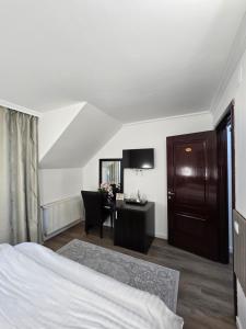 a hotel room with a bed and a desk at Vila CLASS in Vatra Dornei