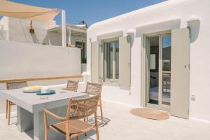 a patio with a table and chairs on a house at Turquoise in Platis Gialos