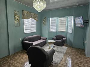 a living room with two couches and a chandelier at Your East Coast Get Away - 43 DougVille in Non-Pariel