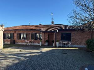 a brick house with chairs and a patio at Residenza dei pini lacchiarella in Lacchiarella