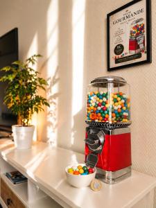 a gumball machine on a counter with a bowl of gumballs at Appartement 2 pieces cosy proche Paris et metro wifi rapide arrivee autonome in Asnières-sur-Seine
