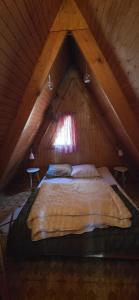a large bed in a attic with a window at Chalet Fontaine 54 in Ustou