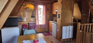 a kitchen with wooden walls and a table in a cabin at Chalet Fontaine 54 in Ustou
