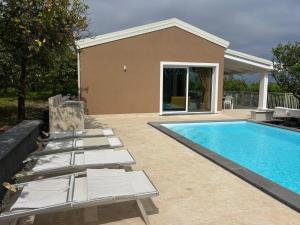 a swimming pool with lounge chairs next to a house at Villa Iulia Hills in Fiumefreddo di Sicilia