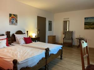a bedroom with a bed and a chair at Altstadthotel Wilde Rose in Eppingen