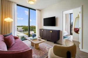 a living room with a couch and a tv at The 27 Wynwood in Miami