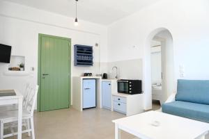 a living room with a green door and a kitchen at Sto Faro - Green in Kithnos