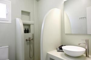 a white bathroom with a sink and a mirror at Sto Faro - Green in Kithnos +19 photos