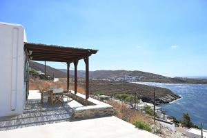 a patio with a table and a view of the water at Sto Faro - Green in Kithnos