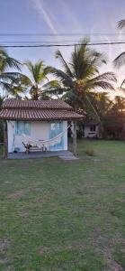 a house with palm trees in front of it at Pousada Safyra in Caraíva
