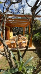 a wooden patio with tables and chairs in a yard at Casa Capivari Boutique in Campos do Jordão