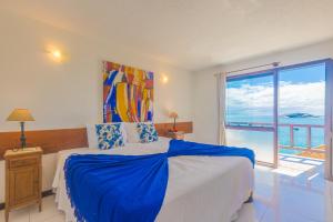 a bedroom with a bed and a large window at La Boheme Hotel e Apart Hotel in Búzios
