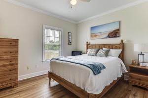 a bedroom with a bed and a dresser and a window at Pool Access! Recently Updated Coastal Retreat in Foley +17 photos