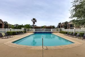 a swimming pool with chairs and a fence at Pool Access! Recently Updated Coastal Retreat in Foley