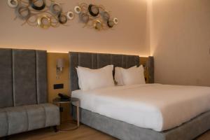 a bedroom with a large white bed and a chair at la Réserve by Duka Winery in Draç