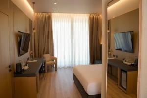 a hotel room with a large white bed and a desk at la Réserve by Duka Winery in Draç