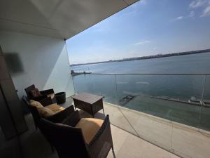 a balcony with a table and chairs and a view of the water at Tudor S Residence Mamaia in Văleni +3 photos