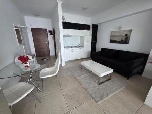 a living room with a black couch and a glass table at Tudor S Residence Mamaia in Văleni