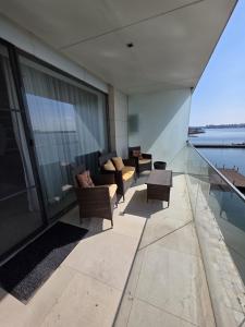a balcony with couches and tables on a building at Tudor S Residence Mamaia in Văleni