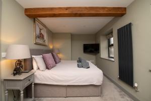 a bedroom with a bed and a desk with a lamp at The Lookout Holmfirth in Holmfirth