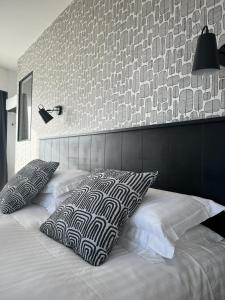 a bedroom with a bed with two pillows on it at Logis Hotel Du Port in Plobannalec-Lesconil