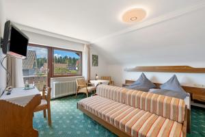 a hotel room with a bed and a couch at Gästehaus Brigitte in Freudenstadt