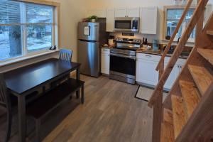 a kitchen with a black table and a refrigerator at Seward Mountain View Cabins #10 in Seward +11 photos