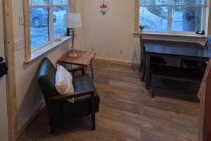 a living room with a chair and a piano at Seward Mountain View Cabins #10 in Seward