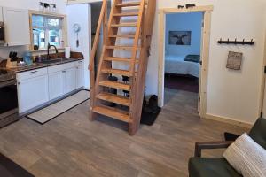 a kitchen with a spiral staircase leading to a living room at Seward Mountain View Cabins #10 in Seward