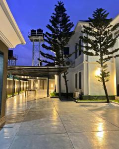 a large white building with a tree in front of it at The Mansion in Abuja
