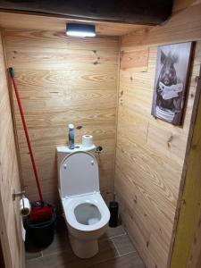 a small bathroom with a toilet in a wooden wall at Grange aménagée in Campan +5 photos