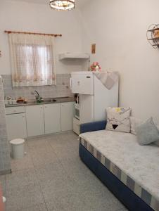 a small kitchen with a bed and a refrigerator at Maria Charalampaki Studios in Skiros