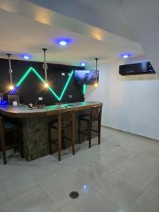 a bar with green lights on a wall at Casa tua in La Loma