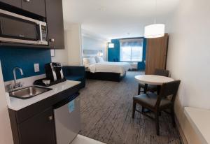 a hotel room with a kitchen and a bedroom at Holiday Inn Express & Suites Logan by IHG in Logan
