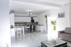 a white living room with a couch and a table at Vila Kabashi in Korçë