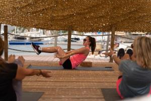 a group of people sitting on a pier doing yoga at Cook's Club Adakoy, Marmaris - Adults Only "Plus 16" in Marmaris