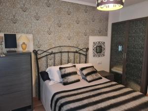 a bedroom with a bed with pillows on it at Ca'Oviedo in Oviedo