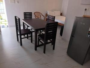 a dining room with a table and chairs and a bed at 1BR Nest in Varkala