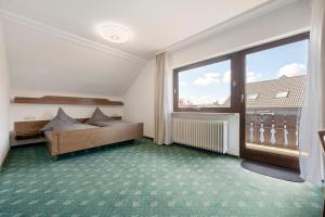 a bedroom with a bed and a large window at Gästehaus Brigitte in Freudenstadt
