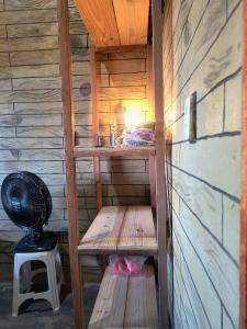 a small room with wooden shelves and a fan at Abrigo de Montanha Quixadá in Quixadá