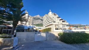 a building with a palm tree in front of it at Downtown Dream Makarska in Makarska