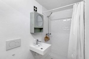 a white bathroom with a sink and a mirror at Portas de Caminha I in Caminha