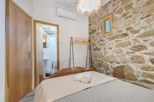 a bedroom with a bed with a stone wall at Casa da Adega in Sá