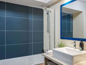 a bathroom with a sink and a shower with a mirror at Aparthotel Adagio Monaco Palais Joséphine in Beausoleil +74 photos