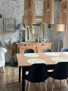 a dining room with a table and chairs and a mirror at le gite de sandrine in Réville +10 photos