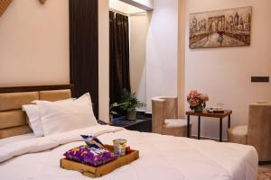 a hotel room with a bed with a tray on it at The Glam By Sandane Homes in Greater Noida