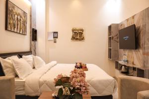 a hotel room with a bed and a table with flowers at The Glam By Sandane Homes in Greater Noida