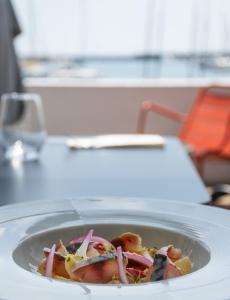 a bowl of food sitting on a table at Logis Hotel Du Port in Plobannalec-Lesconil