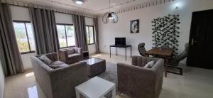 a living room with two couches and a table at Waterfront in Muscat