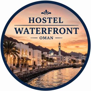 a sign that reads hostel waterfront amani with a river and buildings at Waterfront in Muscat